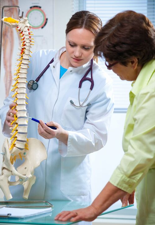 the doctor shows osteochondrosis of the spine on a mock-up
